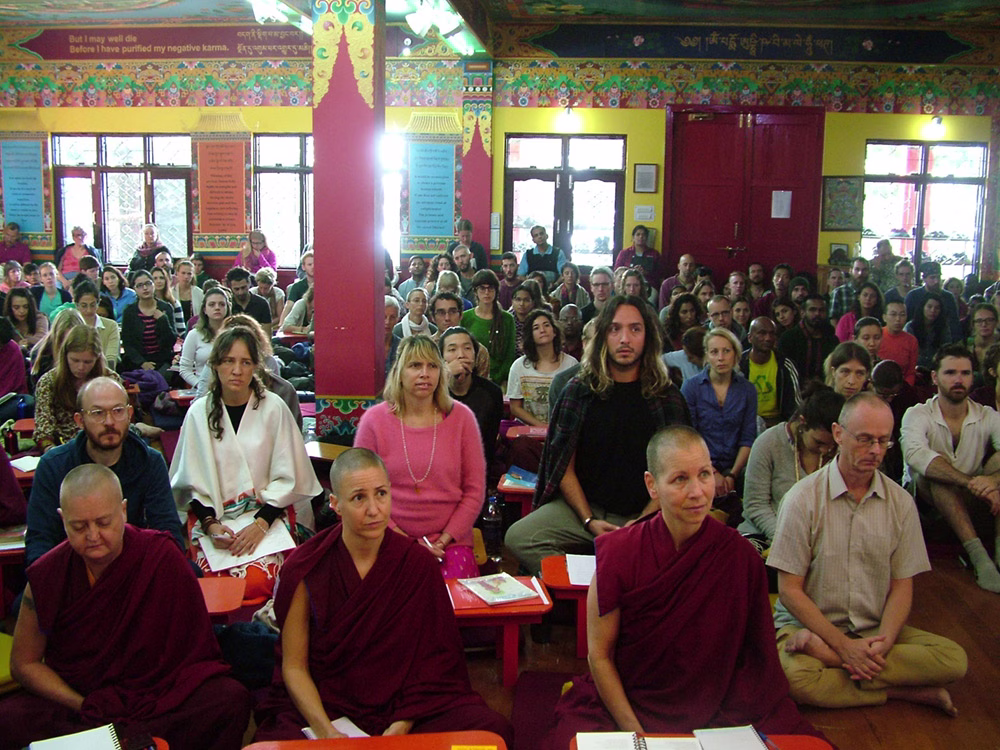 A packed gompa with 120 students from two courses and many visitors filling the aisles.